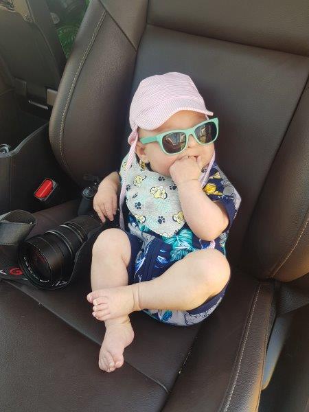 Baby with sunglasses and hat on safari