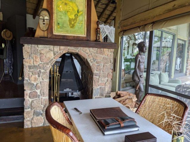 Study area with fireplace and out of Africa styling Singita Ebony Lodge