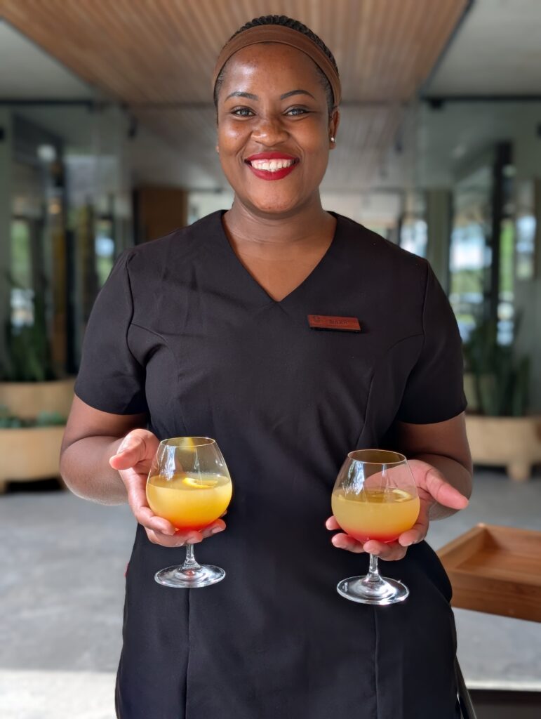 Lady at RockFig Safari Lodge serving cocktail welcome drinks