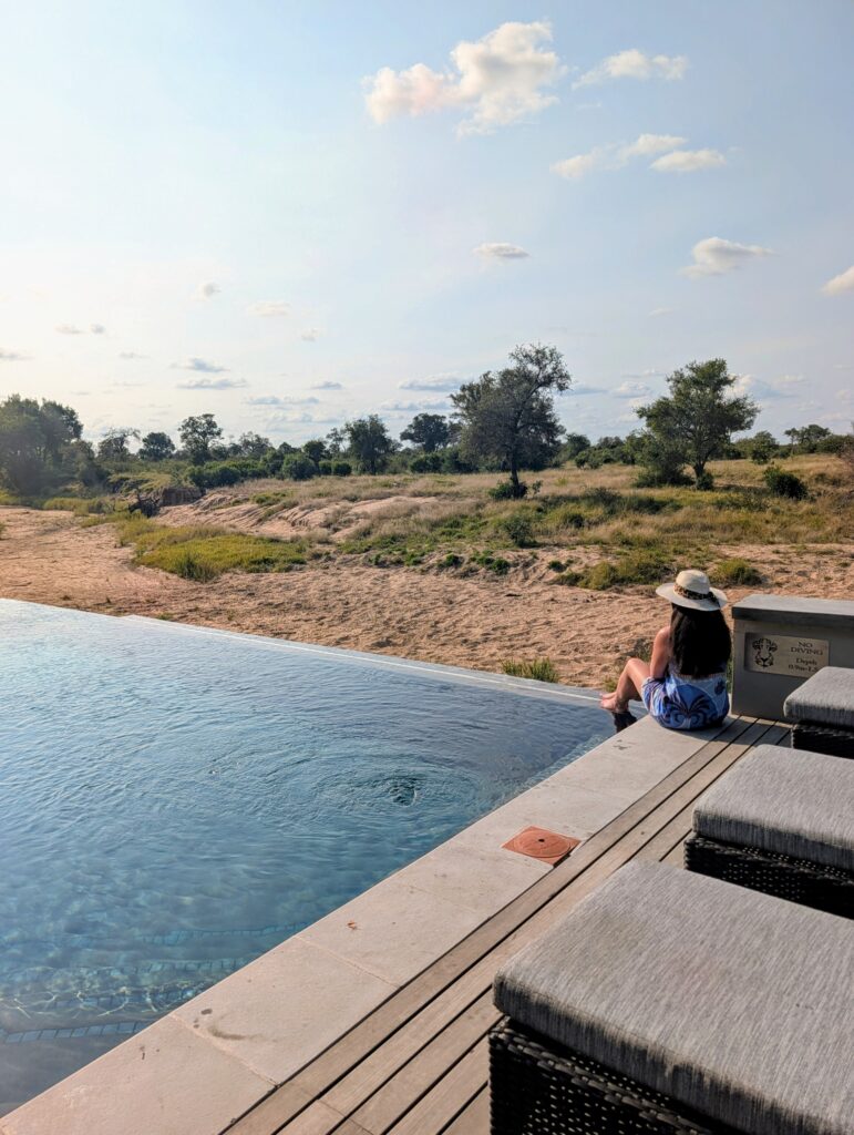 Cara sitting at edge of RockFig Safari Lodge main pool